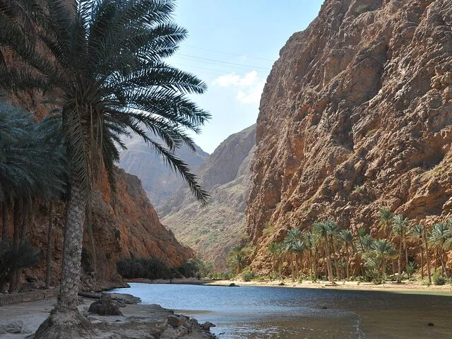 A beautiful view of the river and date palms nestled in Wadi Shab canyon.